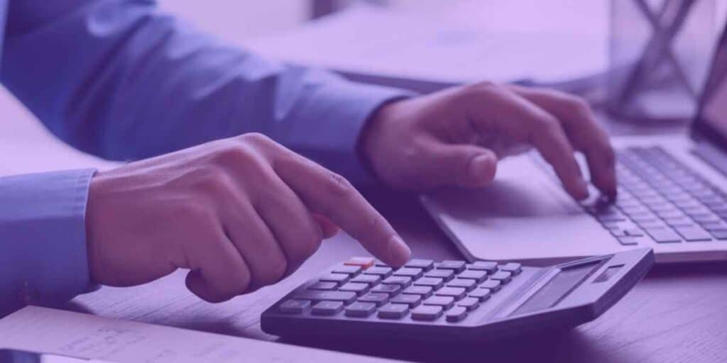 Análise financeira detalhada com calculadora e notebook, representando processos de Recuperação de Crédito para Empresas.